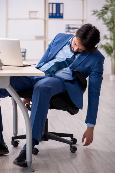 Joven empleado masculino y demasiado trabajo en la oficina — Foto de Stock