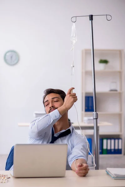 Young male employee suffering at workplace — Stock Photo, Image