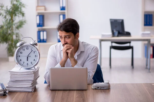 Joven empleado masculino en concepto de gestión del tiempo —  Fotos de Stock