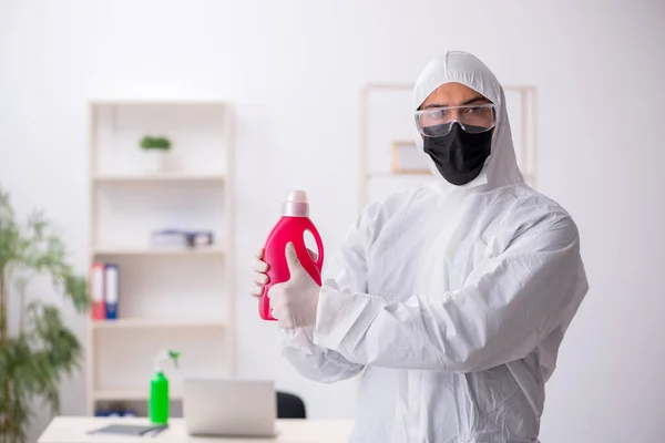 Young male contractor disinfecting office during pandemic — Stock Fotó