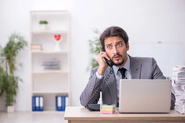 Giovane dipendente maschio e troppo lavoro in ufficio — Foto Stock