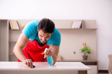 Genç erkek müteahhit evi temizliyor.