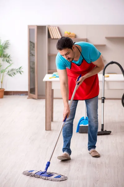 Jovem empreiteiro limpando a casa — Fotografia de Stock