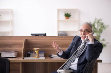 Zaman yönetimi konseptinde yaşlı erkek çalışan