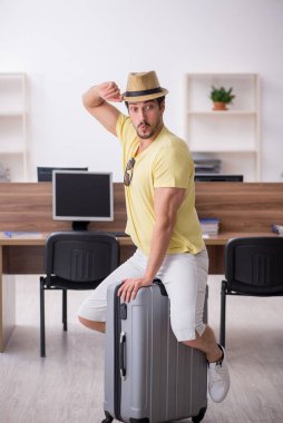 Genç bir erkek işçi iş yerinde geziye hazırlanıyor.