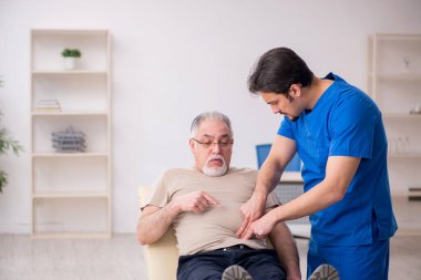 Yaşlı erkek hasta, genç doktor.