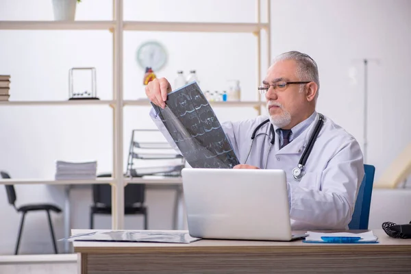 Gammal manlig röntgenläkare som arbetar på kliniken — Stockfoto