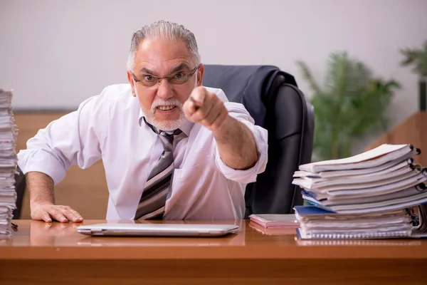 Velho empregado masculino e muito trabalho no escritório — Fotografia de Stock