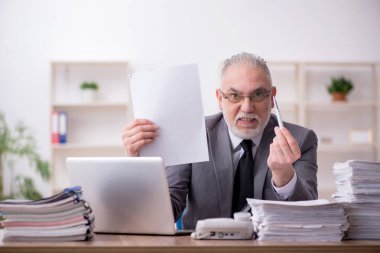 Ofiste çalışan yaşlı bir erkek.