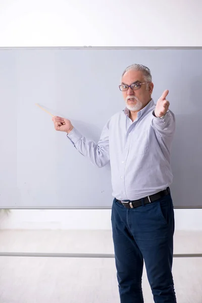 Oude mannelijke leraar voor het whiteboard — Stockfoto