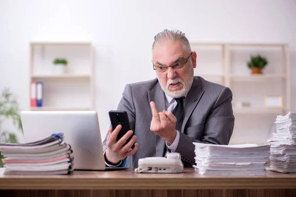 Old male employee working in the office — Stock Photo, Image