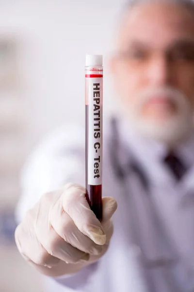 Homem velho médico hematologista que trabalha na clínica — Fotografia de Stock