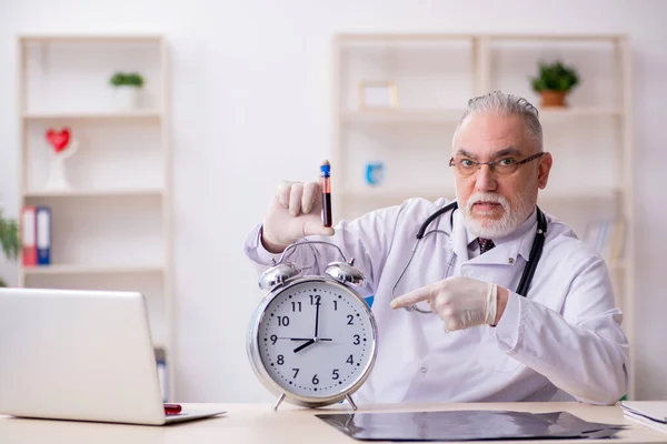 Viejo médico masculino en concepto de gestión del tiempo —  Fotos de Stock