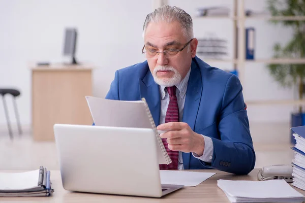 Velho empregado masculino e muito trabalho no escritório — Fotografia de Stock