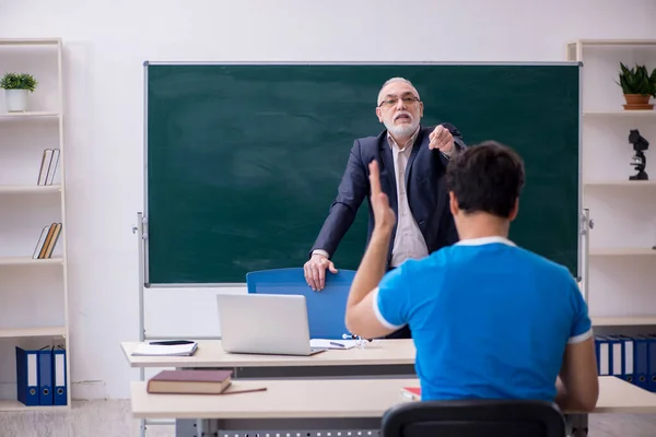 Viejo profesor y joven estudiante delante de la pizarra — Foto de Stock