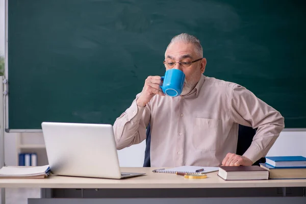 교실에서 커피를 마시는 나이든 남성 교사 — 스톡 사진