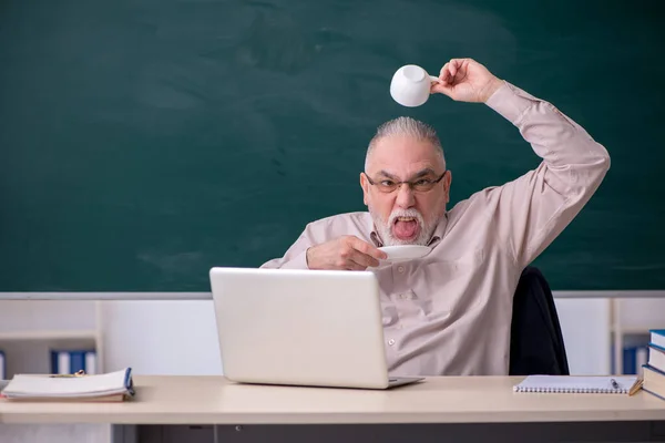 Viejo maestro tomando café en el aula — Foto de Stock