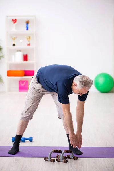 Alter Mann macht Sport im Haus — Stockfoto