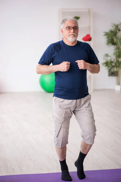 屋内でスポーツの練習をする老人 — ストック写真