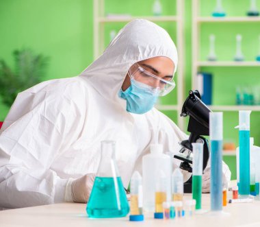 Laboratuvarda yeni bir deney üzerinde çalışan kimyager.