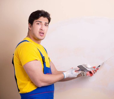 Duvara alçı yapıştıran genç müteahhit.