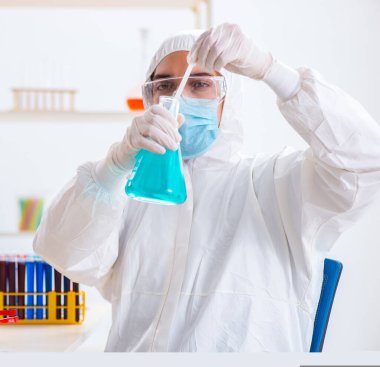 Laboratuvarda kimyasallar üzerinde çalışan genç bir kimyager.