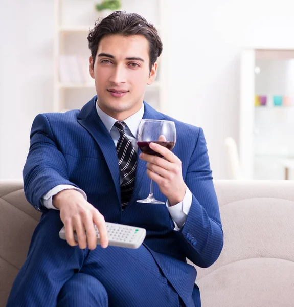 Businessman drinking wine sitting at home — Stock Photo, Image