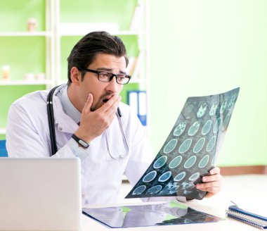 Doktor radyoloji uzmanı hastanede röntgen taramasına bakıyor.