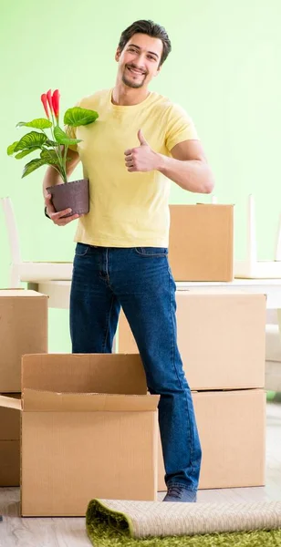 Joven hombre guapo mudándose a casa nueva con cajas —  Fotos de Stock