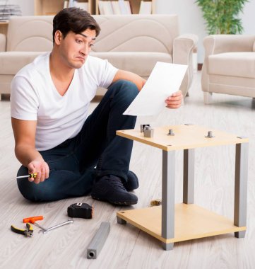 Evdeki rafları monte eden adam