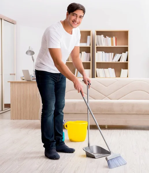 Homem limpando casa com vassoura — Fotografia de Stock