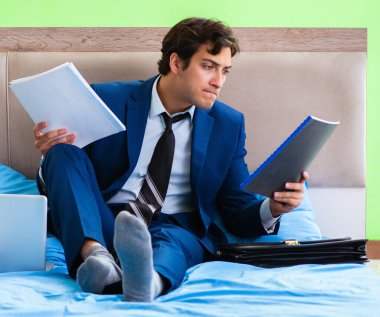 Otel odasında çalışan bir iş adamı.