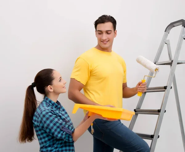 Jovem casal parede de pintura em casa — Fotografia de Stock