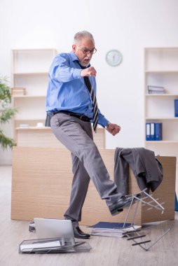 Ofisteki aşırı işten memnun olmayan yaşlı bir erkek işçi.