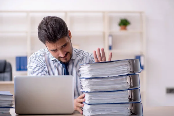 Junge männliche Mitarbeiter und zu viel Arbeit im Büro — Stockfoto