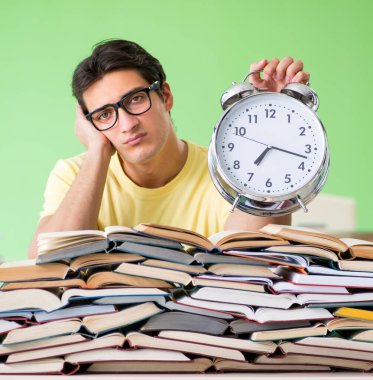 Sınavdan önce okumak için çok fazla kitabı olan öğrenci