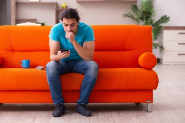 Genç erkek öğrenci salgın sırasında evde oturuyor.