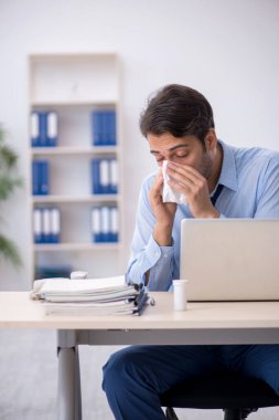 İş yerinde acı çeken genç bir erkek işçi.