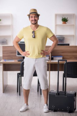 Genç bir erkek işçi iş yerinde geziye hazırlanıyor.