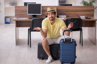 Genç bir erkek işçi iş yerinde geziye hazırlanıyor.