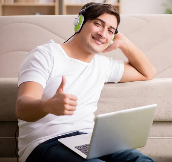 Joven escuchando la música de la computadora portátil —  Fotos de Stock