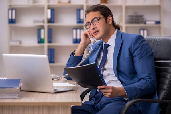 Jeune employé masculin assis dans le bureau — Photo