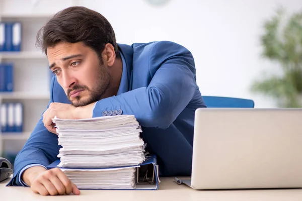 Jovem funcionário masculino infeliz com excesso de trabalho no escritório — Fotografia de Stock