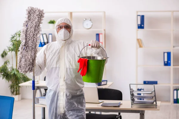 Velho empreiteiro masculino no conceito de desinfecção de escritório — Fotografia de Stock