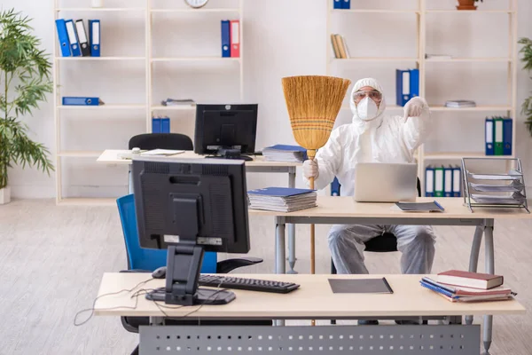 Empreiteiro velho limpando o escritório segurando vassoura — Fotografia de Stock