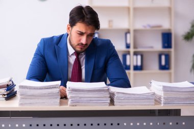Genç işadamı ve ofiste çok fazla iş var.