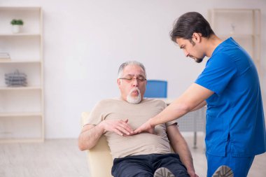 Yaşlı erkek hasta, genç doktor.