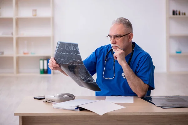 Starý lékař radiolog pracující na klinice — Stock fotografie