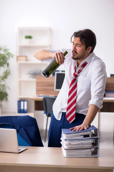 Jovem viciado em álcool empregado do sexo masculino que trabalha no escritório — Fotografia de Stock