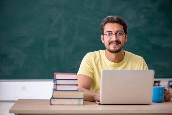 Jonge mannelijke student bereidt zich voor op examens in de klas — Stockfoto